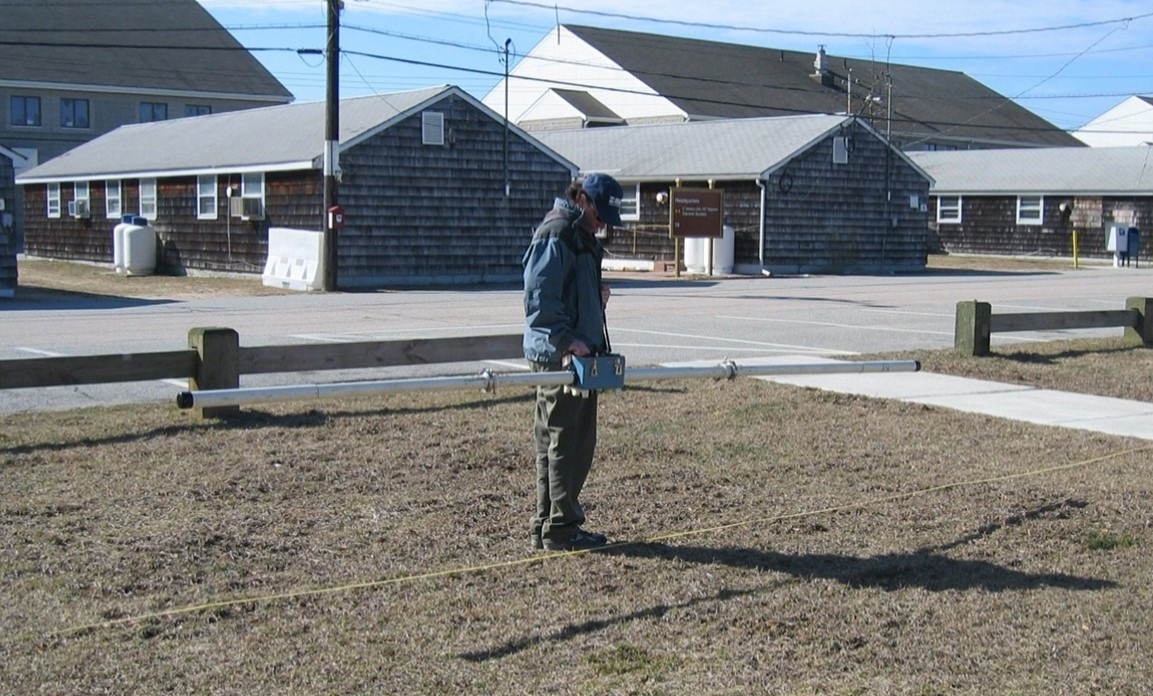 Figure 4. Operator uses a handheld surface EMI tool to collect FDEM data. The transmitter and 
 receiver coils are located on opposite ends of the tool (USGS, 2008).